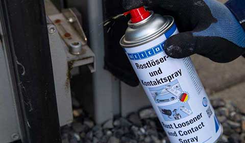 Weicon Rostlöser- und Kontaktspray wird auf die Mechanik eines Rolltors gesprüht
