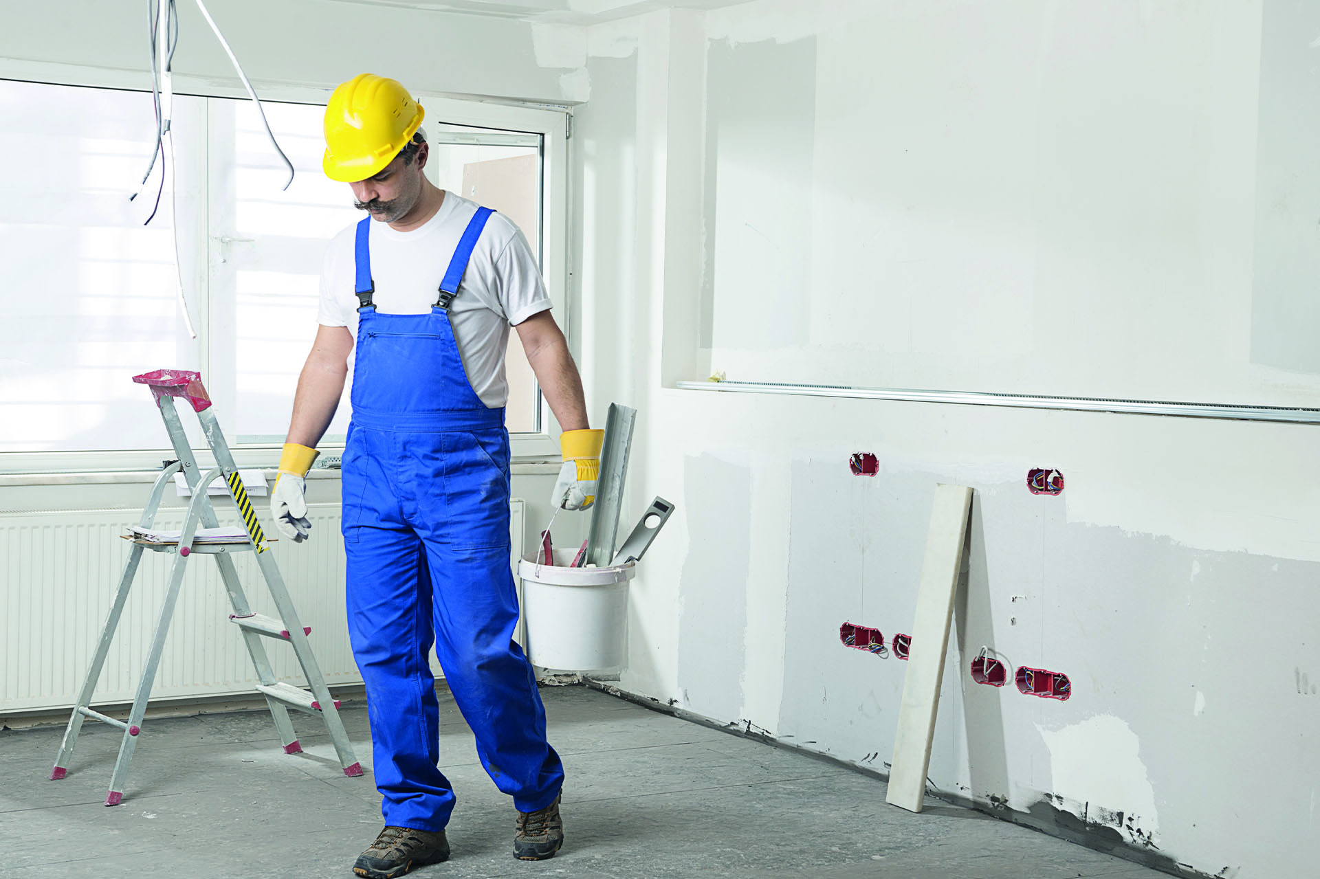 WEICON_Abisolierwerkzeuge-im-Alltag_Renovieren Elektriker mit Blaumann und gelbem Helm