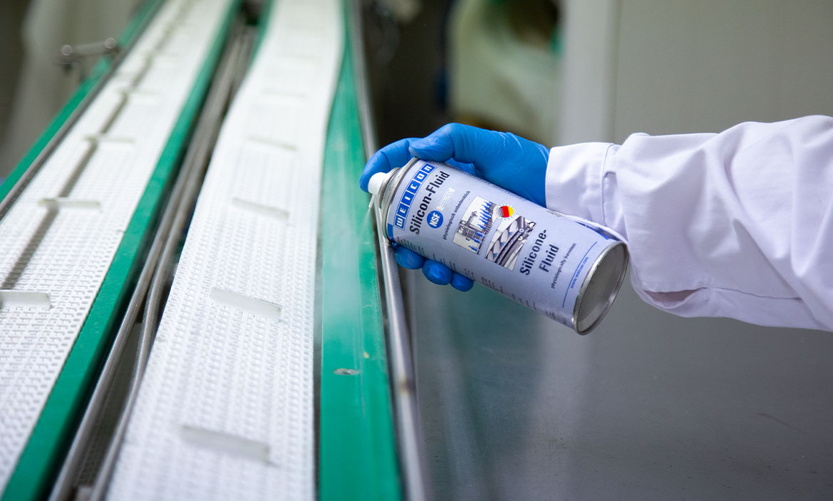 Innovation NSF Weicon Silicon-Fluid wird auf ein Förderband gesprüht