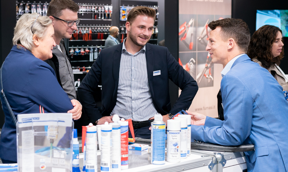 product display, people talking, office attire, sales booth, cosmetics tubes, group, presentation, office, meeting, discussion