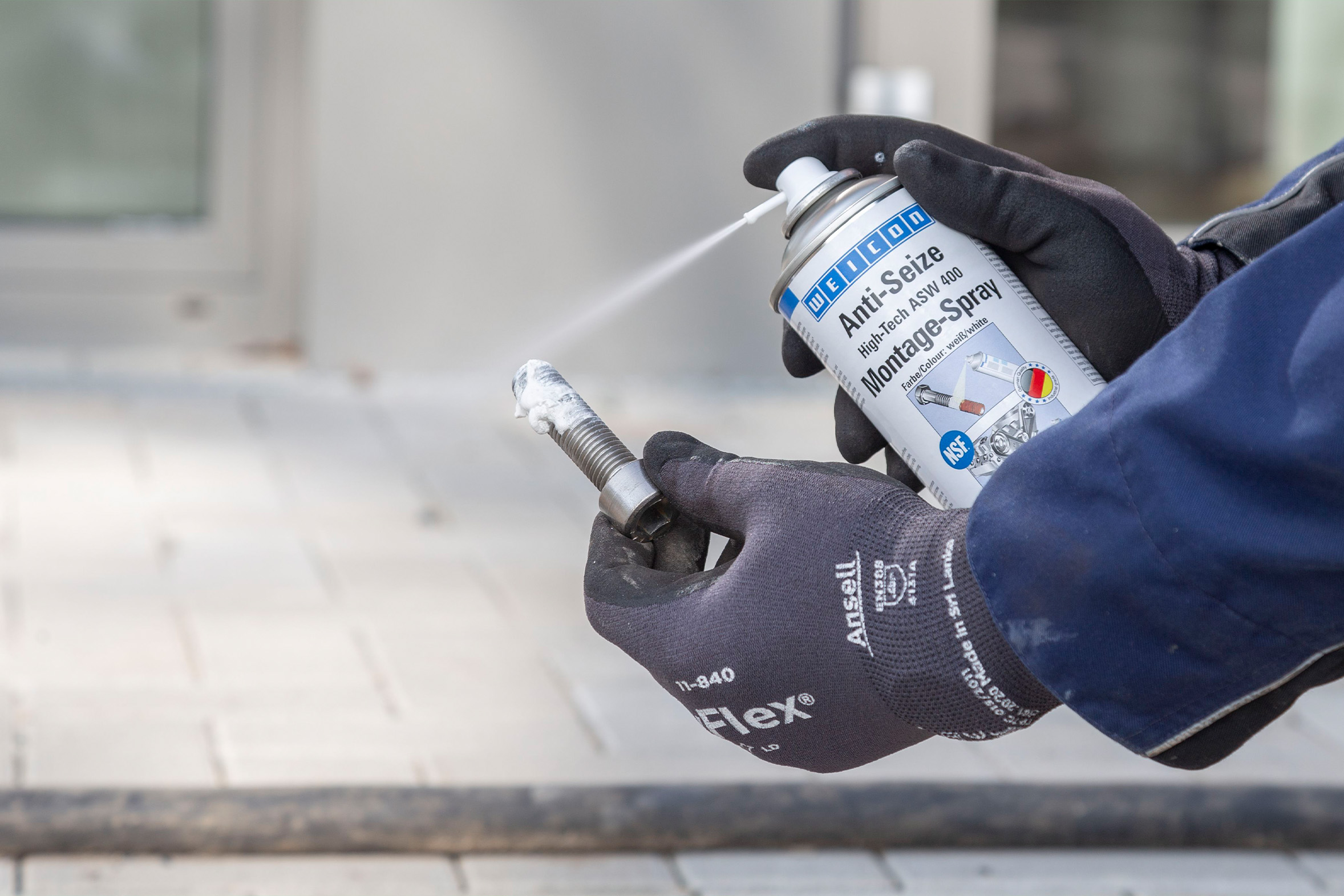 Anti-Seize_High-Tech_metallfreies-Spray Weicon Anti-Seize High Tech Montagespray wird auf Edelstahlschraube gesprüht