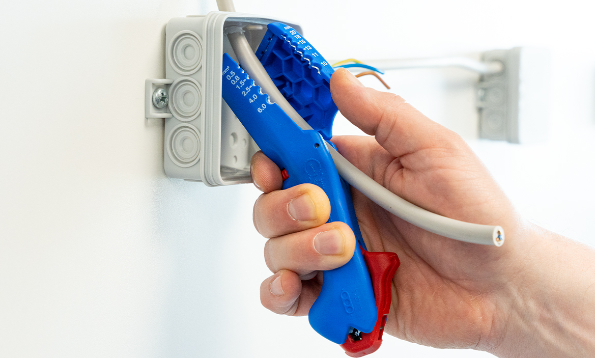 Ein Kabel wird mit dem Weicon Flach- und Rundkabelmesser entmantelt