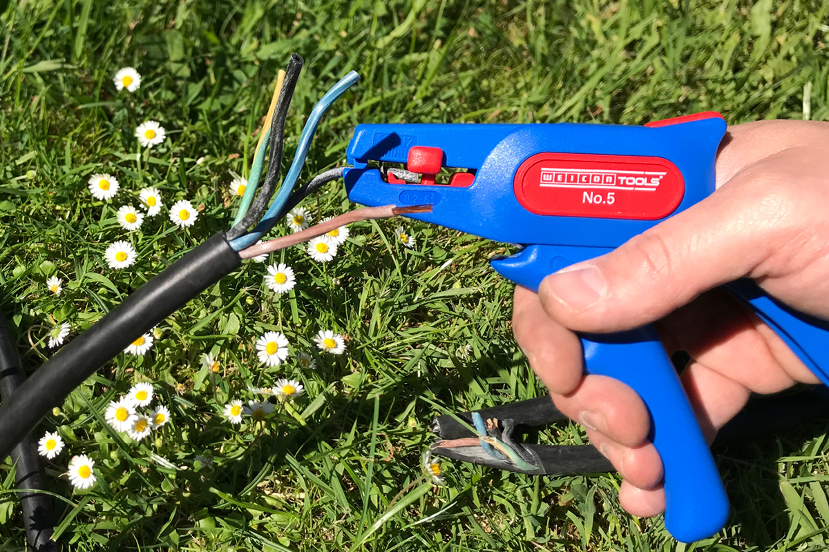 wire stripper, electric tool, blue handle, outdoor, planted in grass