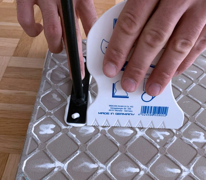 Klebstoffe wird mit einem weißen Spachtel aufgetragen