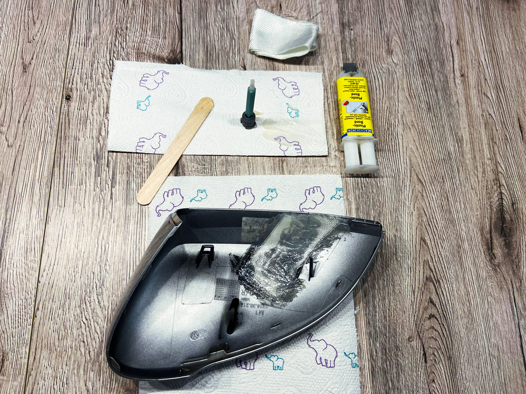 car part, mirror housing, adhesive, syringe, wood surface