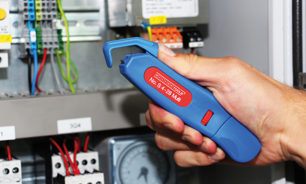 Innovation Kabelmesser S 4-28 Multi Weicon Tools Kabelmesser S 4-28 Multi wird vor einen Schaltschrank gehalten